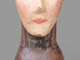 une image représentant un vase en forme de tête en bois sur lequel est peint le visage d'une femme