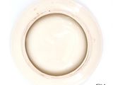 a white plate with a brown rim on a white table