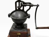 un vieux moulin à café avec un socle et une poignée en bois