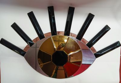 une photo d'une horloge composée de couteaux et d'un miroir