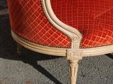 orange upholstered chair in front of a brick wall