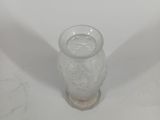 a small glass cup sitting on a white surface