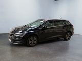 Une voiture noire est garée dans une pièce aux murs blancs.
