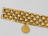 l'image d'un bracelet en or surmonté d'une pièce de monnaie
