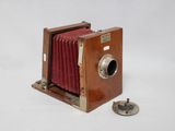 un petit appareil photo en bois avec un cache rouge
