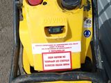 a yellow lawn mower with a sign on it