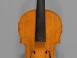 an old violin with a bow hanging on a wall