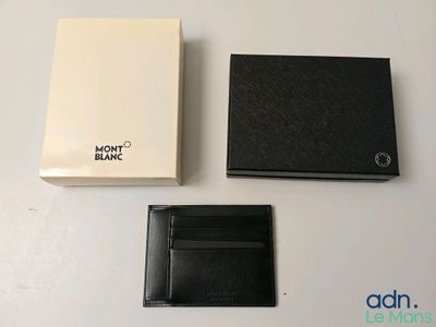 deux portefeuilles noirs et une boîte blanche posés sur une table