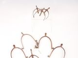 trois paires de boucles d'oreilles en argent posées sur une surface blanche, sur fond blanc