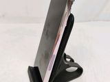 a close up of a cell phone on a stand on a white surface