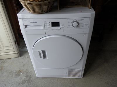 a washing machine with a basket on top of it