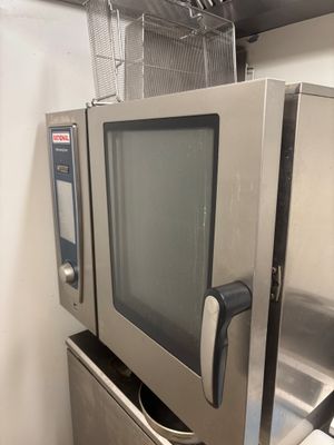 un micro-ondes posé sur un réfrigérateur dans une cuisine
