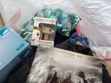 a pile of items that include a doll, a book, a pillow, and other items