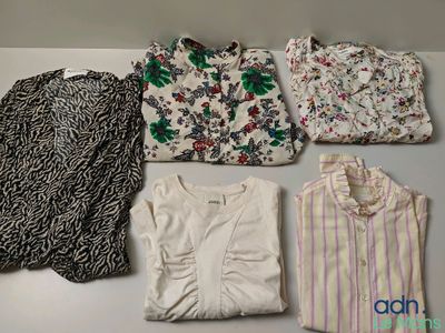 several shirts and tops are laid out on a table