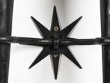 a metal star that is attached to a metal fence