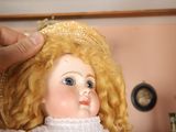 a doll with blonde hair wearing a straw hat