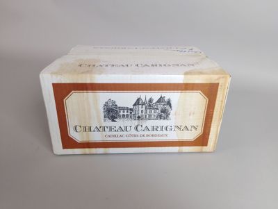 une photo d'un carton de vin « Château Carignan » posé sur une table