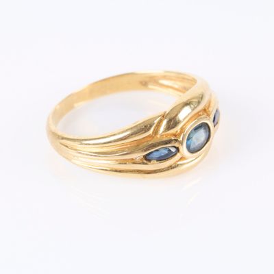 Gros plan sur une bague en or ornée de pierres bleues