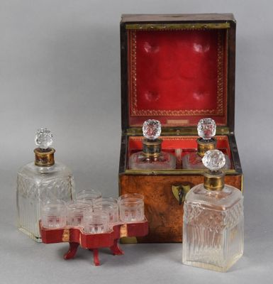 trois bouteilles en verre et une boîte en bois avec un couvercle rouge