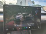 someone holding a tablet in their car with a picture of a car on the screen