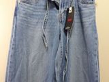 a pair of jeans hanging on a hanger in a room
