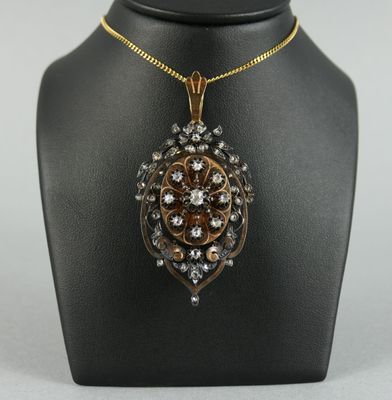 un pendentif en or et diamants sur un collier de mannequin