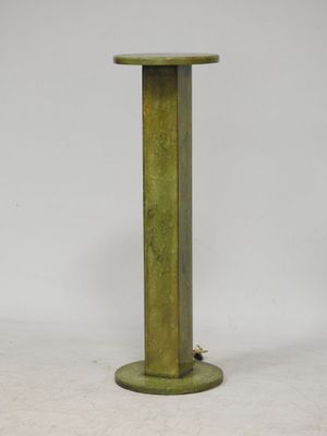 un socle métallique vert, avec une base ronde et un plateau rond