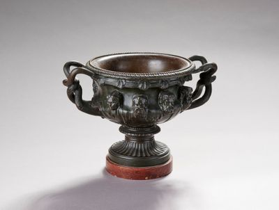 une image représentant un vase en bronze muni de deux anses, posé sur un socle en bois