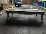a table in the middle of a parking lot with a car parked in the background