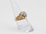 an image of a gold ring with a blue topaz stone in it