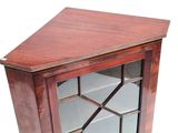 a small wooden cabinet with a glass door on it
