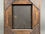 an old wooden picture frame with a black picture in the middle