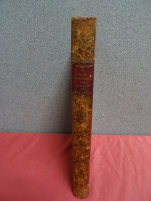 un vieux livre posé sur une table recouverte d'un tissu rose