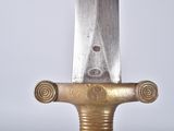 a close up of a sword on a white surface