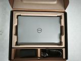 a dell laptop in a box with a charger