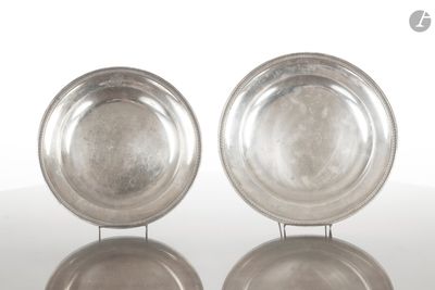 paire de plats en argent plaqué posés sur un support, sur un fond blanc avec reflet