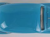 an overhead view of a blue classic car on a white surface