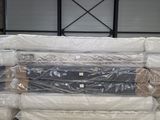 de nombreux matelas empilés les uns sur les autres dans un entrepôt