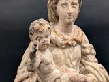 an old statue of a woman holding a baby in her arms