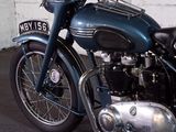 a blue motorcycle parked in a garage with a white wall
