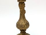 a gold vase with a bird on top of it