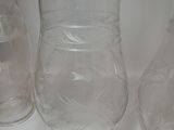 three clear glass vases are lined up on a white surface