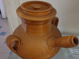 un grand vase marron posé sur une table en verre