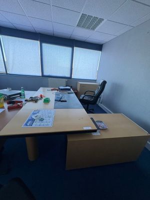 une photo d'un bureau vide avec un bureau et des chaises