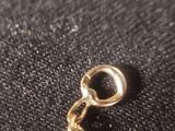 a close up of a gold chain on a black cloth
