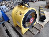 a yellow blower sitting on a pallet in a warehouse