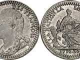 a silver coin with the image of a man and woman on it