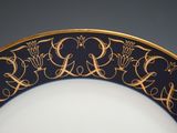 a black and gold plate with gold writing on it