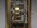 an image of a gold clock with a black face and a metal frame