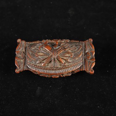 une boucle de ceinture ancienne en bois sculpté, ornée d'un motif de dragon